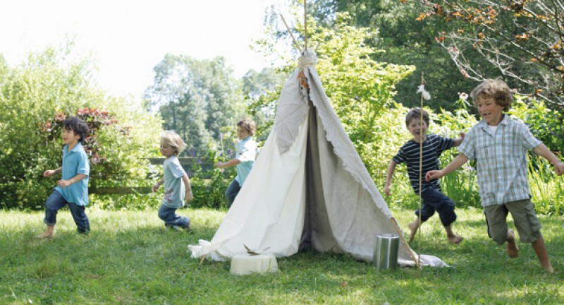 Kinder rennen um ein Zelt